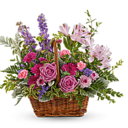 Basket arrangement of pink and purple flowers with lilies and roses