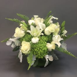 White roses and lilies with green hydrangeas in a low vase