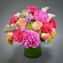 Pink and peach mixed bouquet in a green glass vase