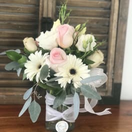Pink and white roses with white daisies in a glass vase
