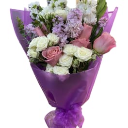Bouquet of pink and white roses wrapped in purple paper