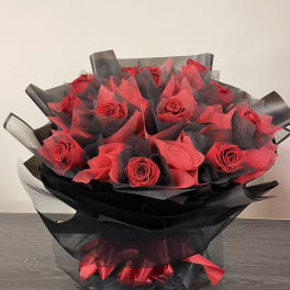 Bouquet of red roses wrapped in black and red paper