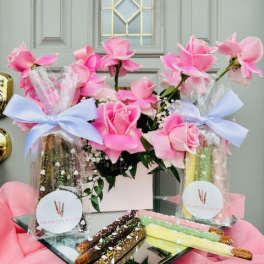 Pink roses in gift bags with chocolate-covered pretzel rods on a tray