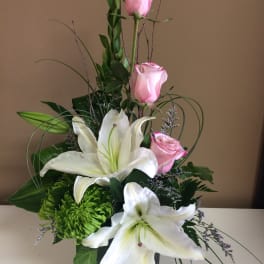Pink roses and white lilies in a glass vase