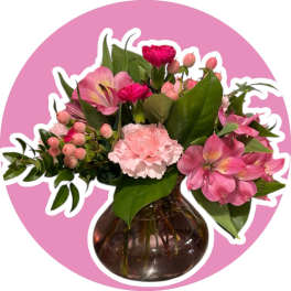 Pink flowers arranged in a round glass vase