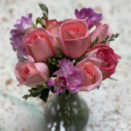 Pink roses and purple flowers in a glass vase