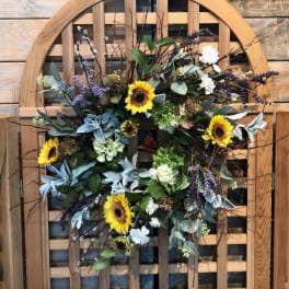 Sunflower wreath with purple accents on a wooden chair back