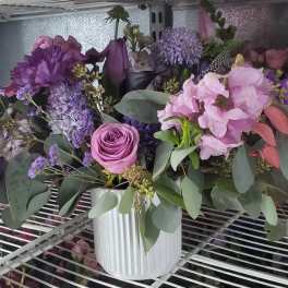 Purple and pink mixed bouquet in a white vase