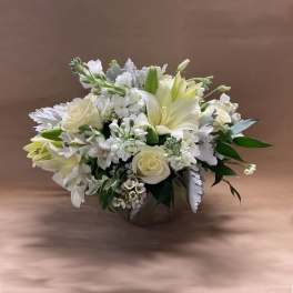 White floral arrangement in a low round container