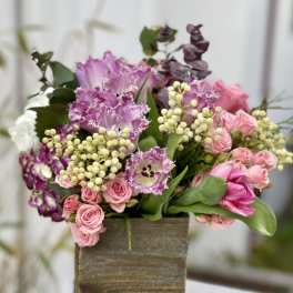 Pink and purple floral arrangement in a wooden box