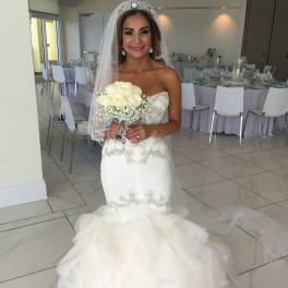 Bride holding a bouquet of white roses at a wedding reception