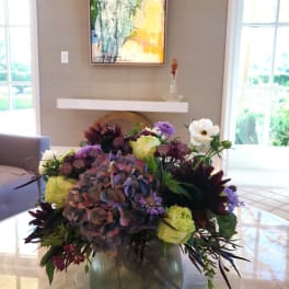 Mixed bouquet in a glass vase with purple, white, and yellow flowers