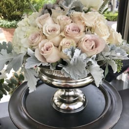 Cream and blush roses arranged in a silver pedestal bowl