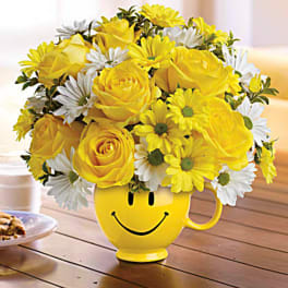 Yellow and white flower bouquet in a smiley-face mug