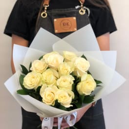 Bouquet of pale yellow roses wrapped in white paper