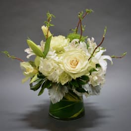 White floral arrangement in a green glass vase