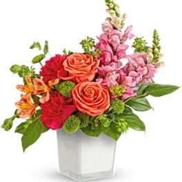 Colorful bouquet of roses and snapdragons in a white vase