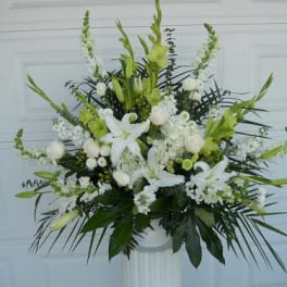 White and green floral arrangement in a pedestal vase