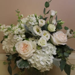 White roses and hydrangeas in a dark vase