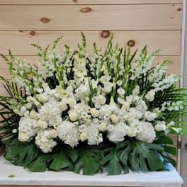 Large white floral arrangement with tall spikes and broad green leaves