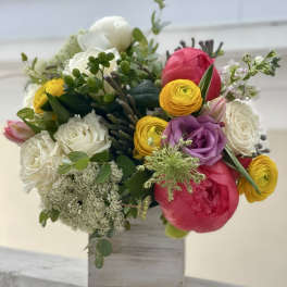 Colorful bouquet of roses and ranunculus in a wooden box