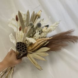 Dried bouquet with cream flowers, seed pods, and brown grasses