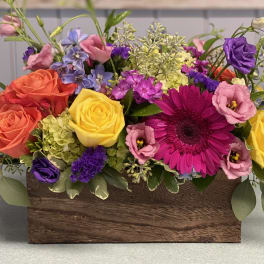 Colorful mixed flower arrangement in a wooden box