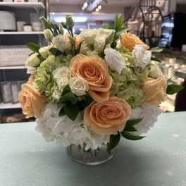 Peach and white rose bouquet with hydrangeas in a glass vase