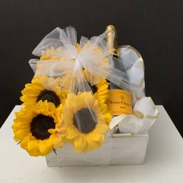 Sunflowers arranged with a champagne bottle in a white gift box
