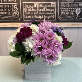 Pink and white daisy bouquet in a square white vase