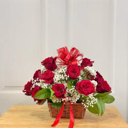 Basket of red roses with baby's breath and a red ribbon bow