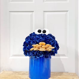 Blue flower arrangement with cookie eyes and a blue container