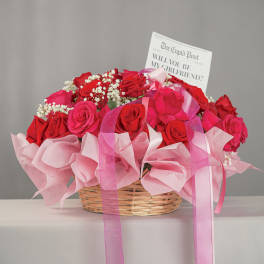 Basket of red and pink roses with a card and pink ribbon
