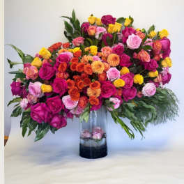 Large mixed rose arrangement in a clear glass vase