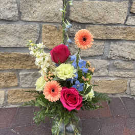 Mixed bouquet in a clear glass vase with pink roses and peach gerbera daisies
