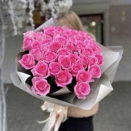 Large bouquet of bright pink roses wrapped in paper