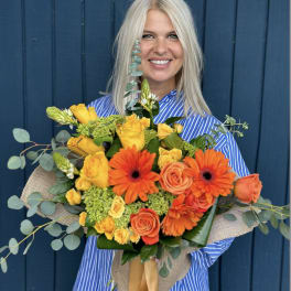 Woman holding a bouquet of orange and yellow flowers
