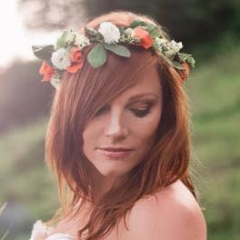 Woman wearing a floral crown with white and coral flowers