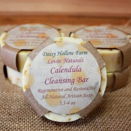Three labeled calendula cleansing soap bars on burlap