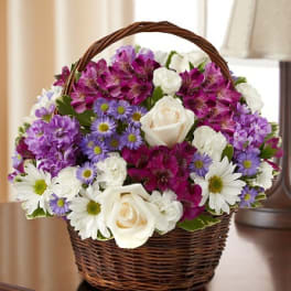 Basket of white roses, purple flowers, and daisies