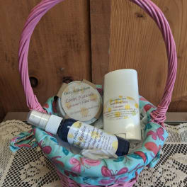 Pink wicker basket with soap and spray bottles on a table