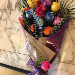 Bouquet of multicolored roses wrapped in purple and brown paper