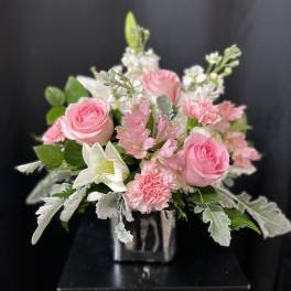 Pink roses and white lilies in a clear square vase