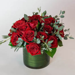 Red roses arranged in a green cylindrical vase