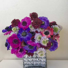 Bouquet of purple, pink, and white flowers in a clear glass vase