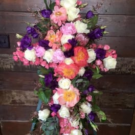 Cross-shaped floral arrangement with pink, white, and purple flowers
