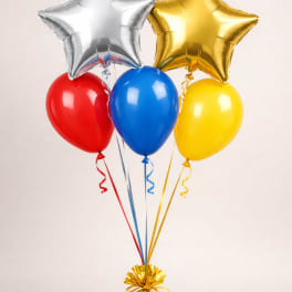 Cluster of red, blue, and yellow balloons with silver and gold star balloons tied to a gold weight.