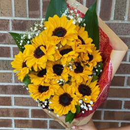 Bouquet of yellow sunflowers with baby's breath in brown paper