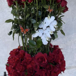 Tall red rose arrangement with white orchids in a silver vase