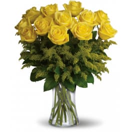 Arrangement of yellow roses with filler flowers in a clear glass vase